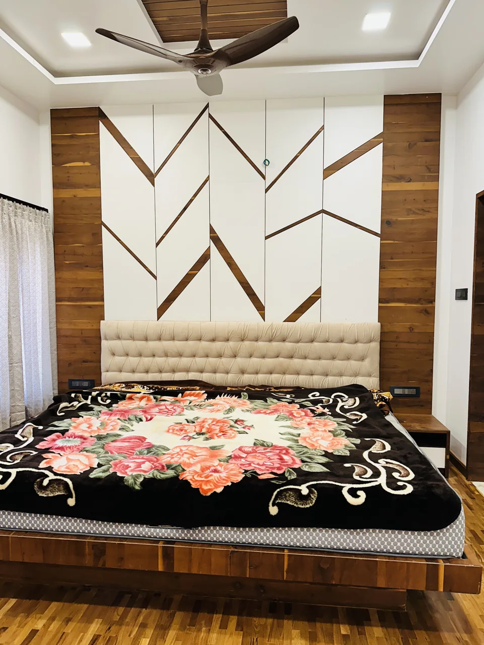 Bedroom featuring geometric wall panels, timber accents and recessed ceiling lights