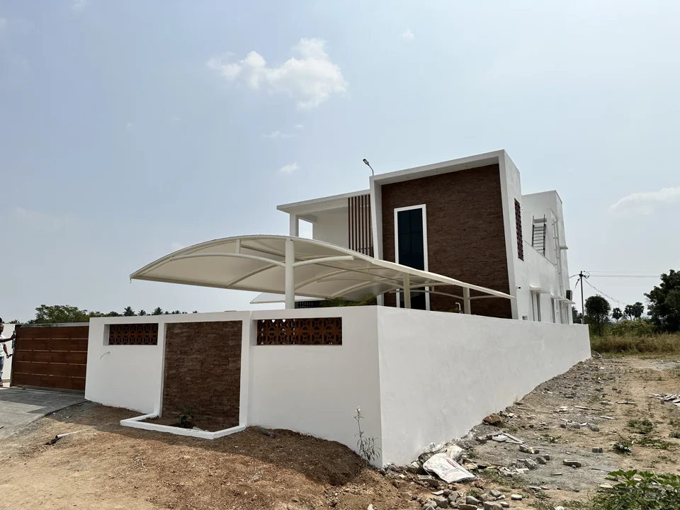 White residence with a timber-clad volume and a curved tensile canopy over the parking