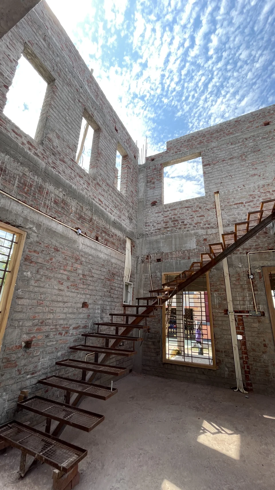 Stair construction within unfinished masonry walls under an open roof