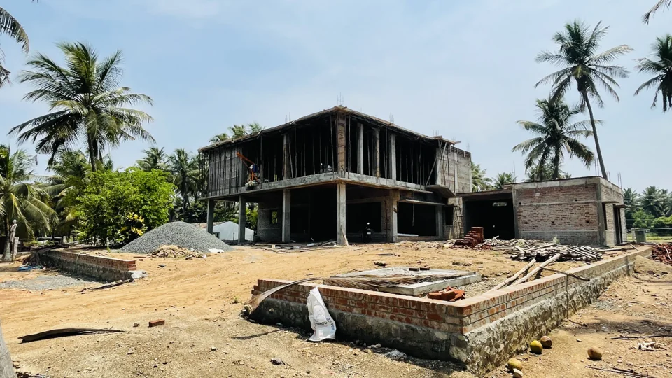 Concrete structural frame under construction with site materials in the foreground